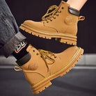 NEWYORKLISTED: Tan work boots with brand logo on a dark background