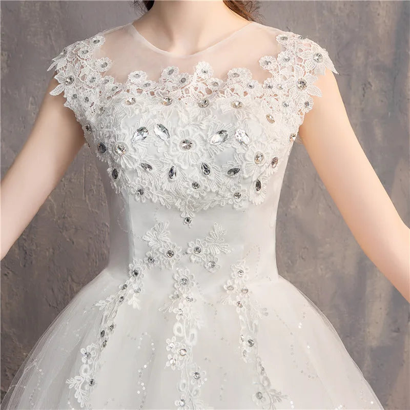 White lace dress with floral and crystal details on a neutral background
