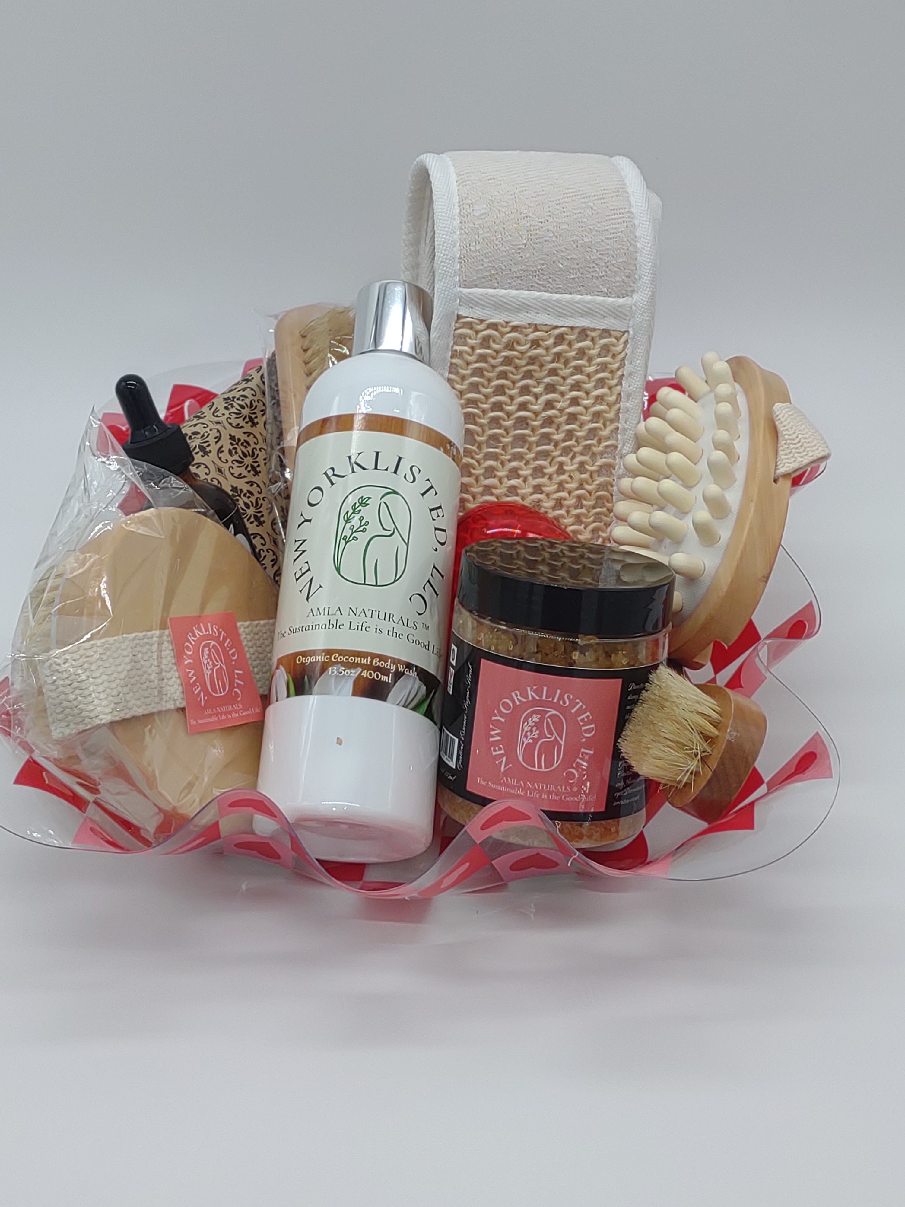 NEWYORKLISTED Valentine’s Day Luxury Spa Gift Basket, Set of grooming products including a bottle, brush, and other items on a white background