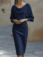 Woman wearing NEWYORKLISTED cowl neck knit bodycon dress in soft stretch cotton with sleeveless fitted midi silhouette.