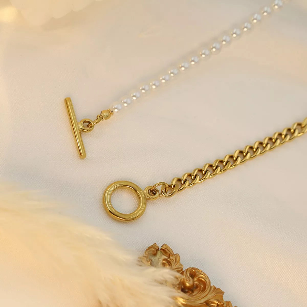 NYLD Glamour Collection by NEWYORKLISTED: Gold chain necklace with clasp on a light background