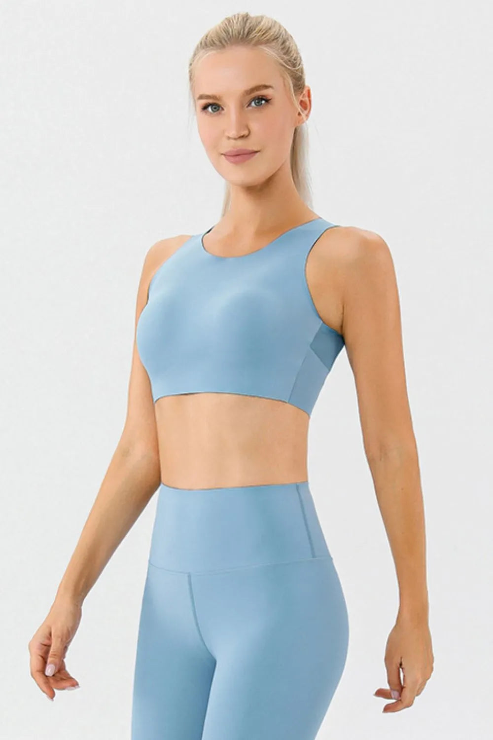 NEWYORKLISTED ACTIVEWEAR COLLECTION: Woman wearing a light blue athletic outfit on a white background