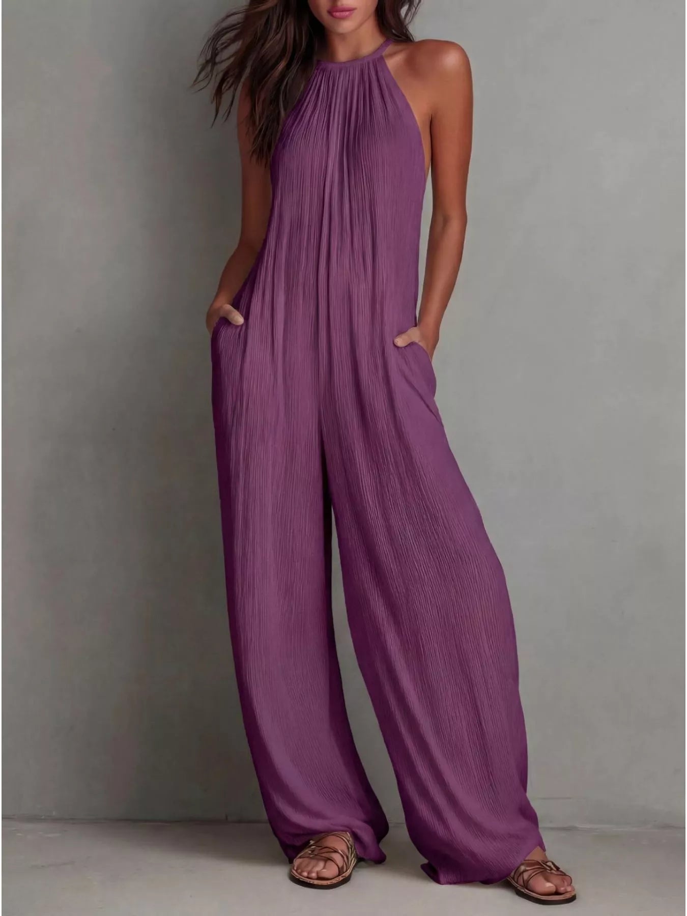 NEWYORKLISTED STYLE COLLECTION: Woman wearing a purple jumpsuit against a gray background