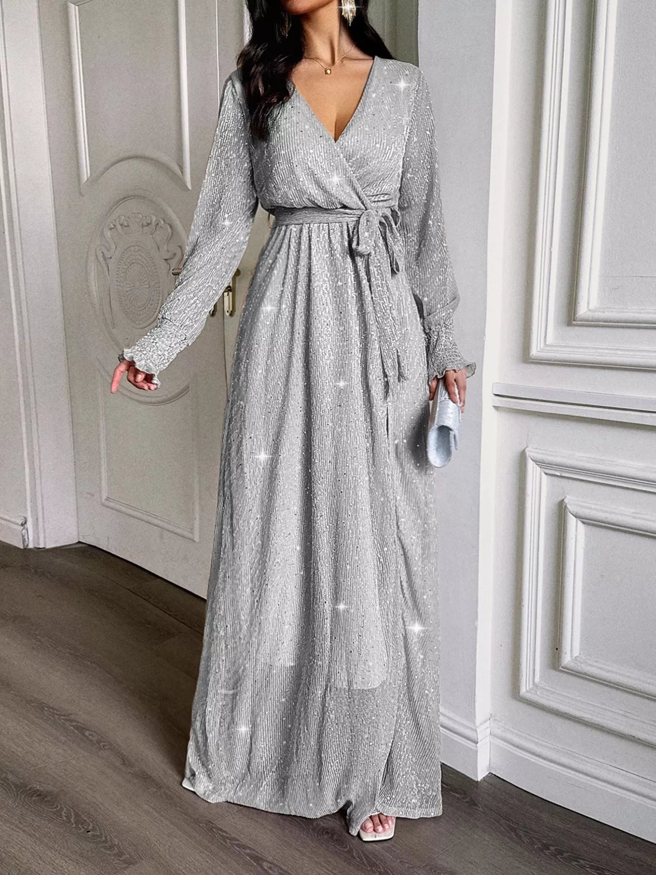 NEWYORKLISTED STYLE COLLECTION: Woman wearing a silver sequin dress in an elegant interior setting