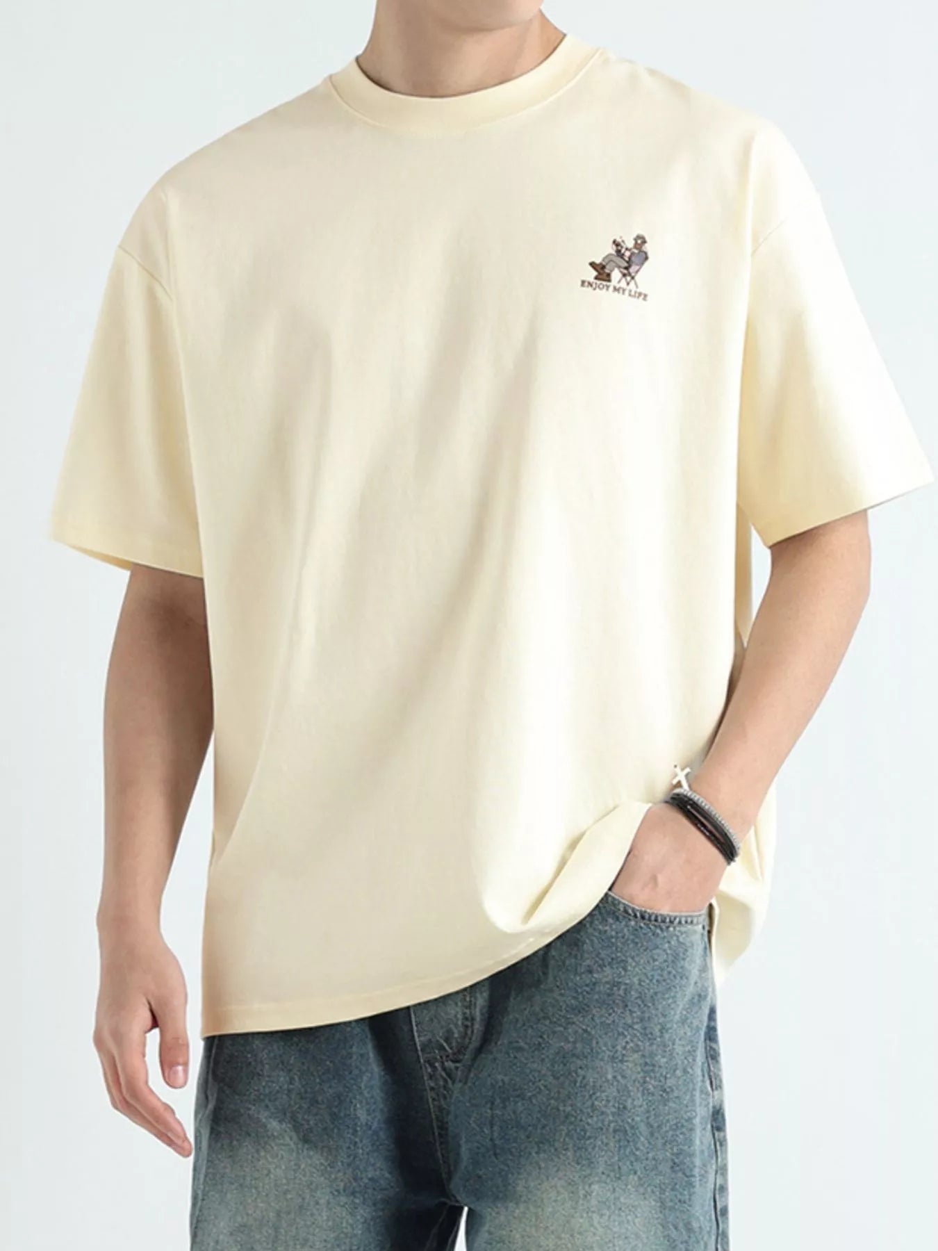 NEWYORKLISTED ATLAS MEN'S COLLECTION: Person wearing a beige t-shirt with a small logo on a plain background