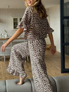 NEWYORKLISTED Intimate Apparel Collection: Leopard Print Ruffle Trim Top and Pants Lounge Set: Woman wearing a leopard print outfit in a home setting