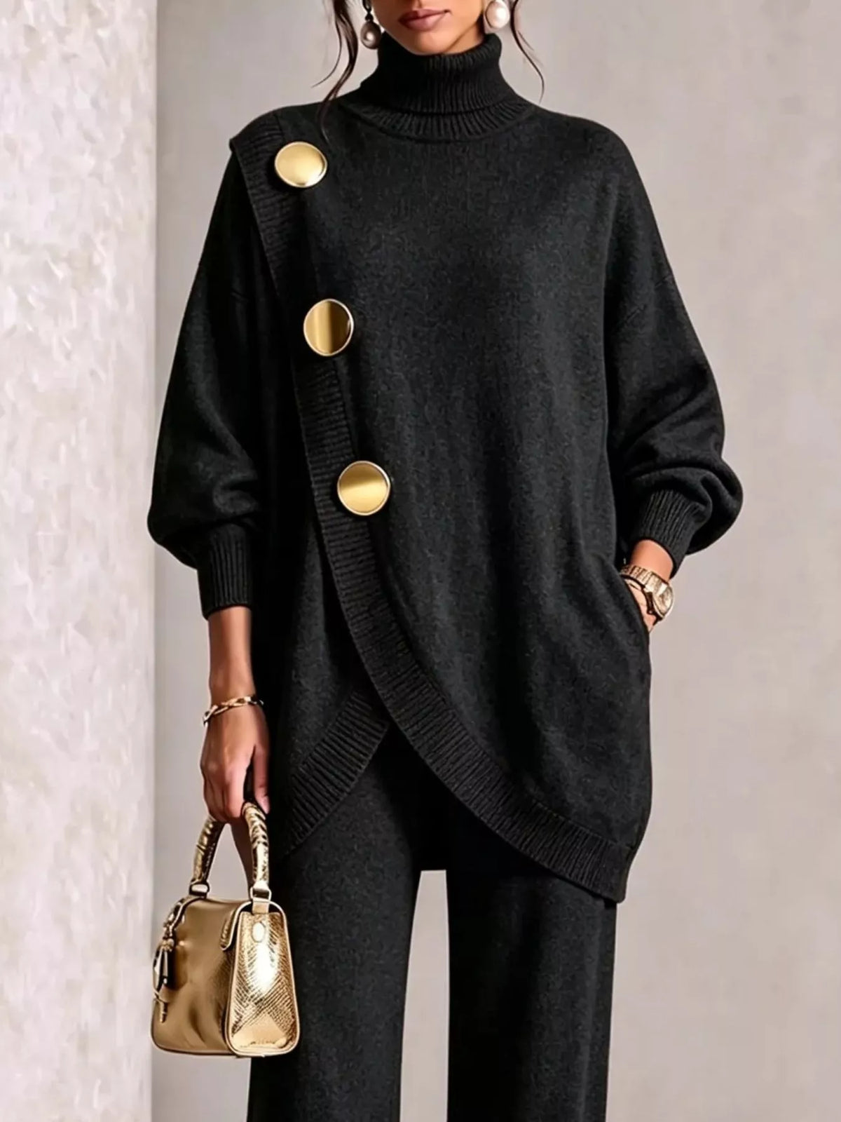 NEWYORKLISTED STYLE COLLECTION:  A woman models a black oversized turtleneck sweater with asymmetrical gold buttons, paired with black pants and holding a small metallic gold handbag.
