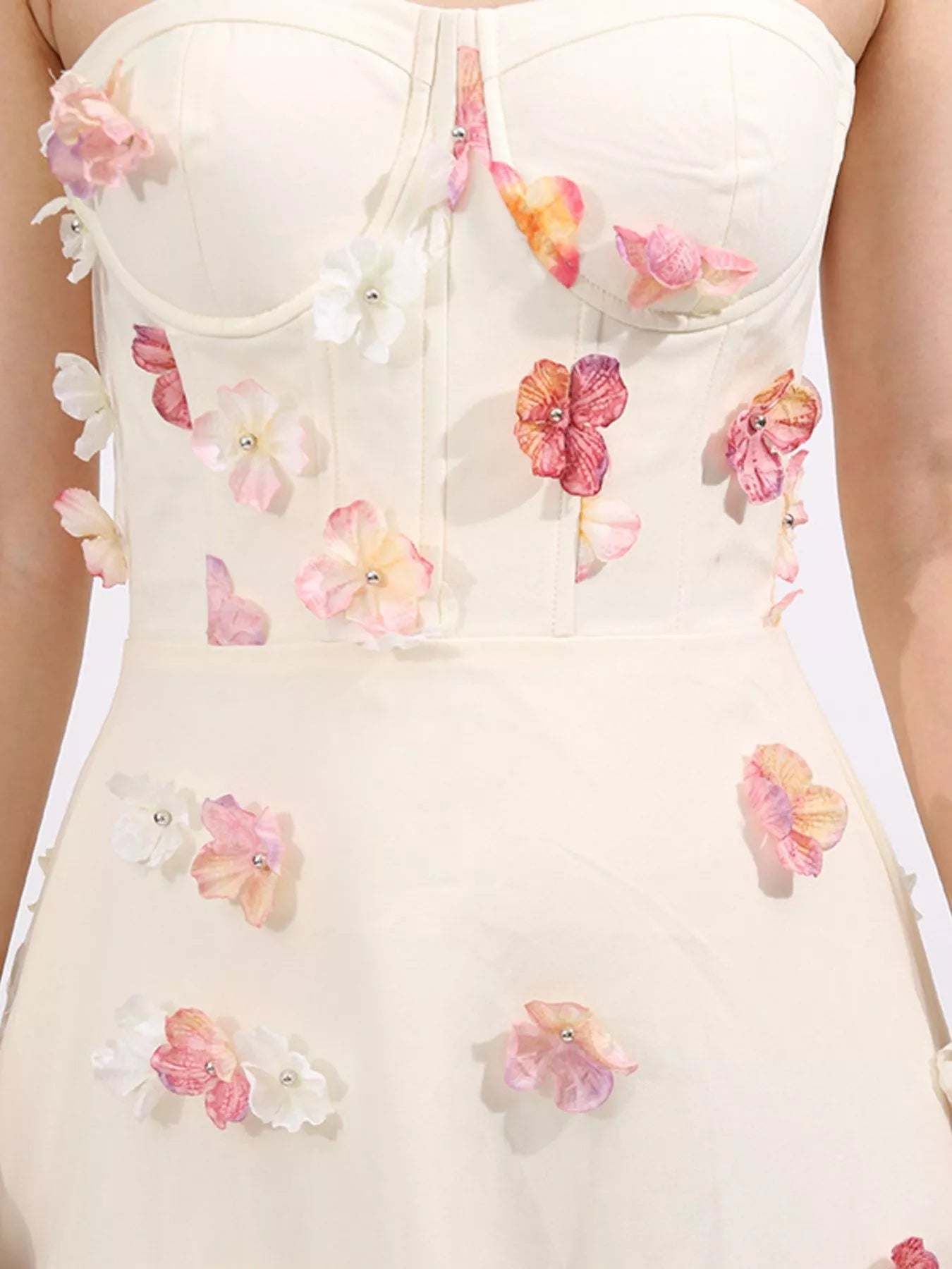 NEWYORKLISTED STYLE COLLECTION: White strapless dress with floral embellishments on a white background