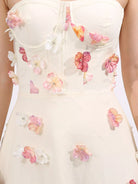 NEWYORKLISTED STYLE COLLECTION: White strapless dress with floral embellishments on a white background