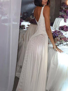 NEWYORKLISTED STYLE COLLECTION: Woman in a white dress standing in front of a decorated table with purple flowers.