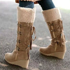 NEWYORKLISTED SHOE COLLECTION: Tan knee-high boots with fringes and white fur lining worn on a blurred background