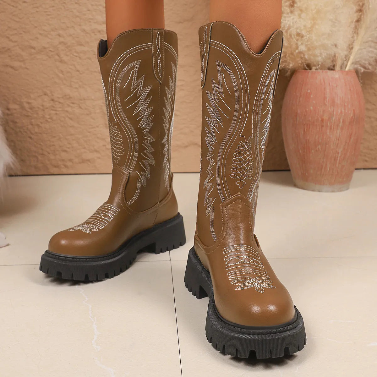 NEWYORKLISTED SHOE COLLECTION: Round Toe Block Heels Boots: Brown cowboy boots with detailed stitching on a light background
