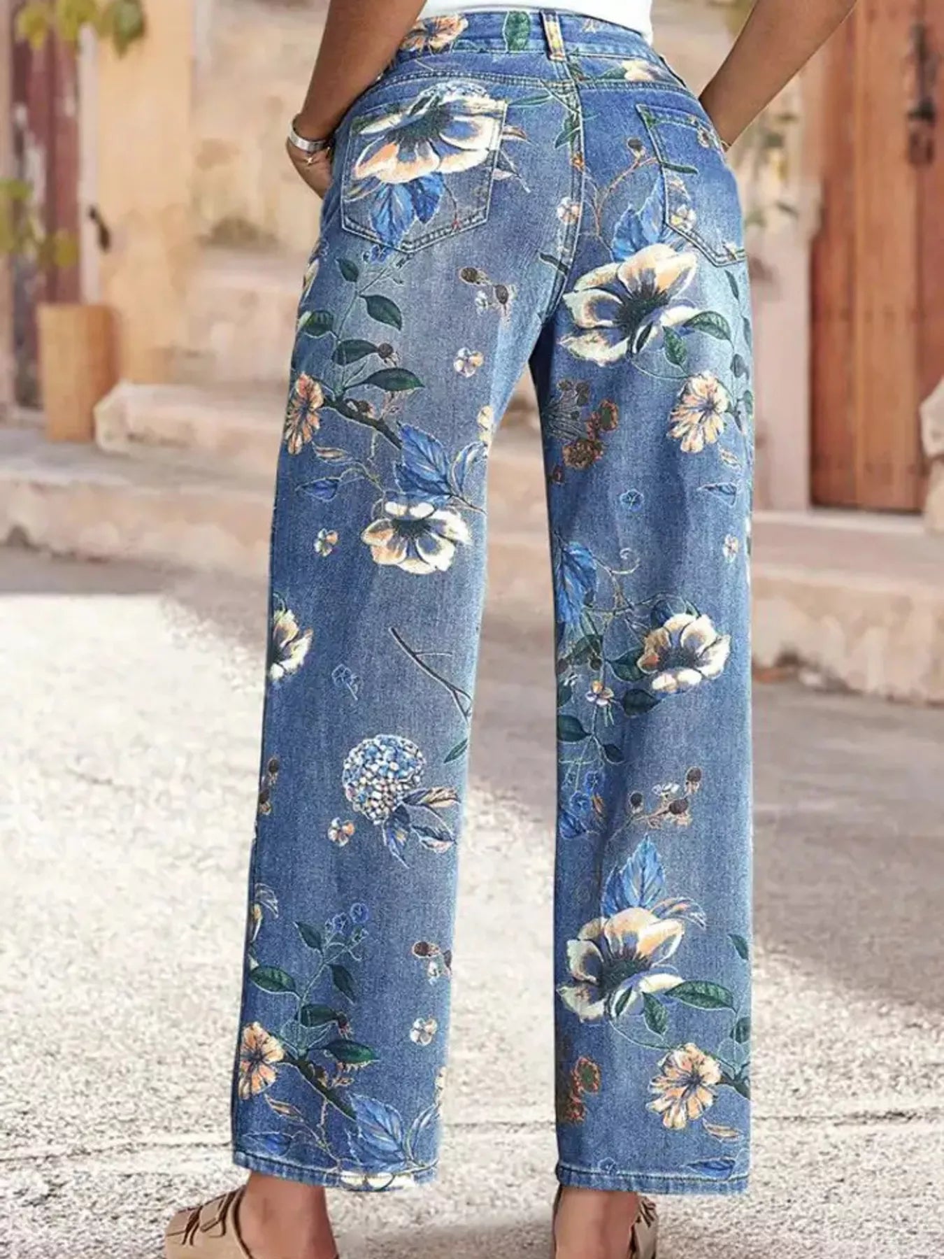 NEWYORKLISTED STYLE COLLECTION: Floral-patterned blue jeans worn by a person on a street.