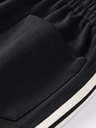 NEWYORKLISTED ATLAS MEN's COLLECTION: Close-up of black pants with a white stripe on a white background