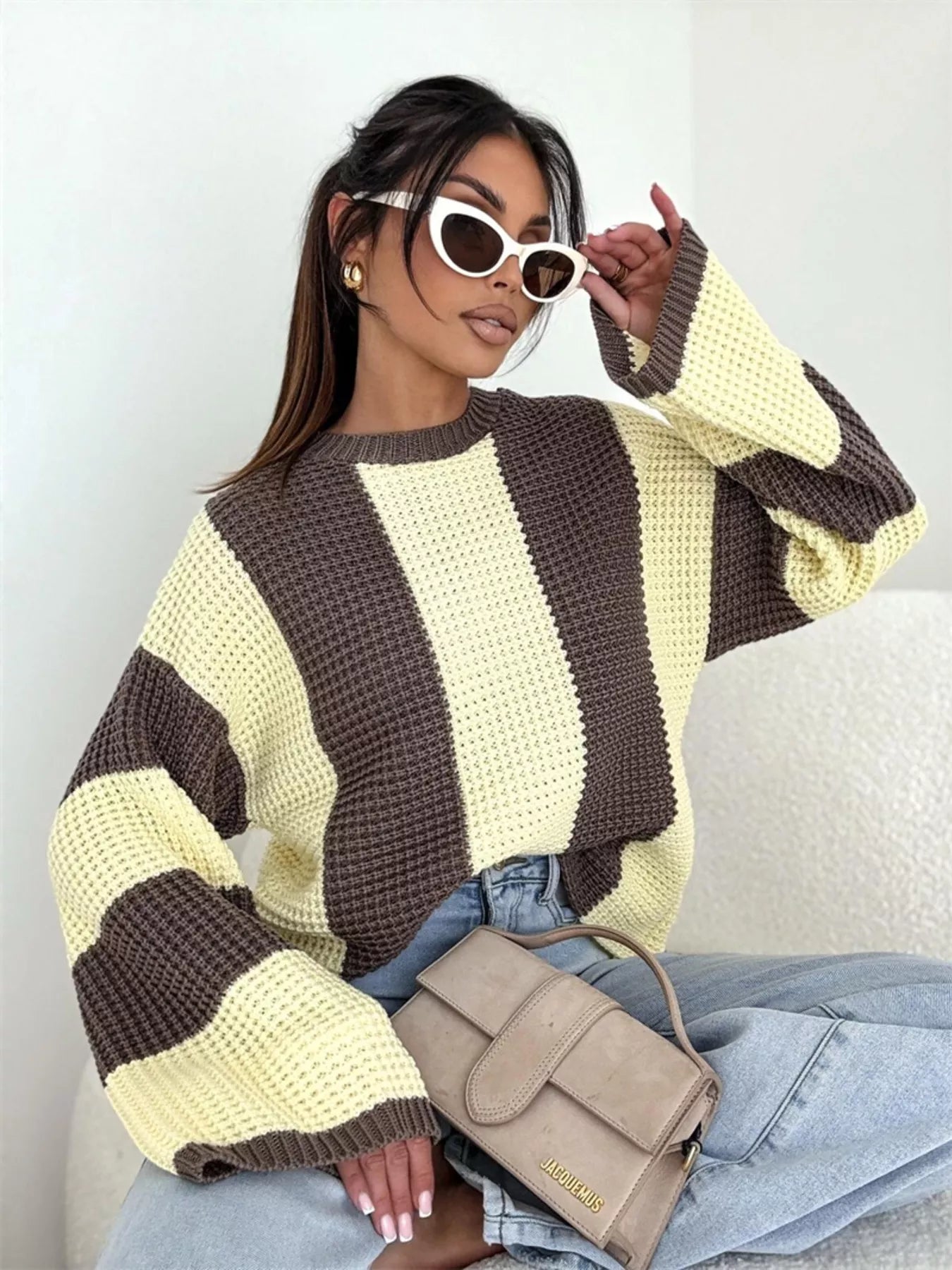 NEWYORKLISTED STYLE COLLECTION: Woman wearing a striped sweater with a neutral background