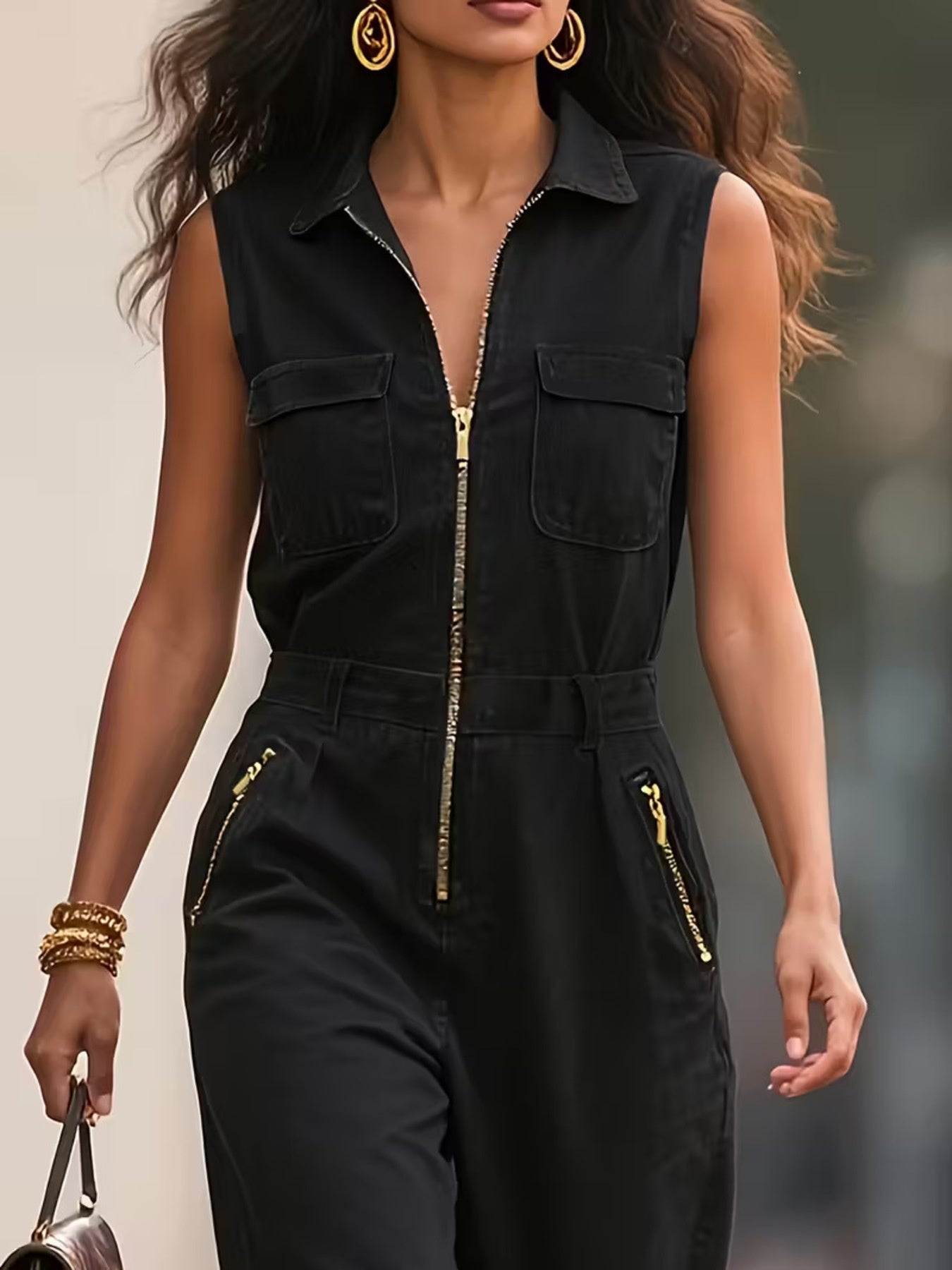 NEWYORKLISTED STYLE COLLECTION: Woman wearing a black sleeveless jumpsuit with gold zippers against a blurred background