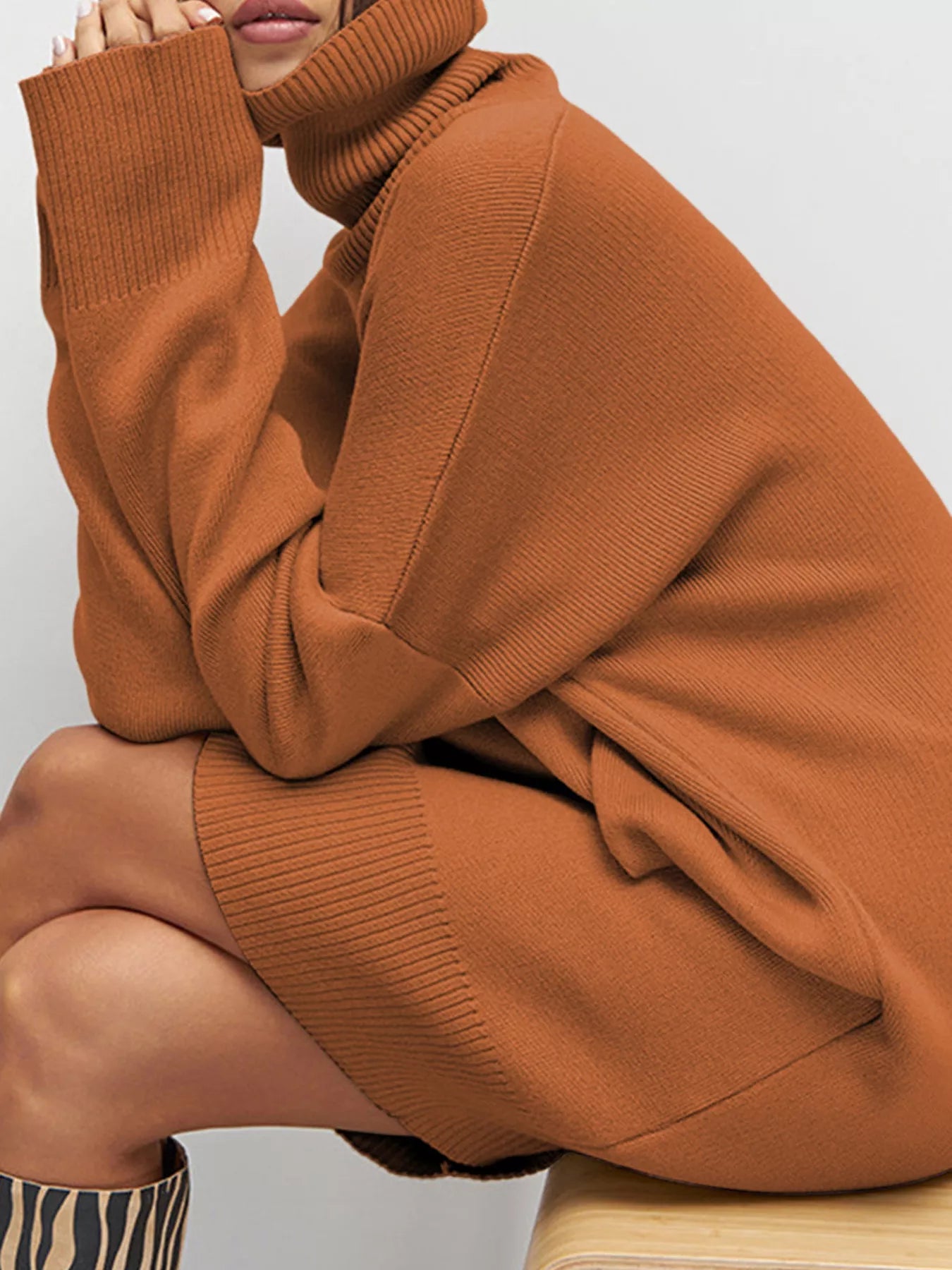 NEWYORKLISTED STYLE COLLECTION: Person wearing a brown sweater with a plain background