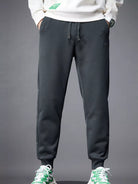 NEWYORKLISTED ATLAS MEN's COLLECTION: Person wearing dark gray jogger pants with a plain background