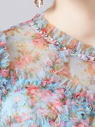 NEWYORKLISTED STYLE COLLECTION: Floral dress with ruffled details and pearl embellishments on a blurred background