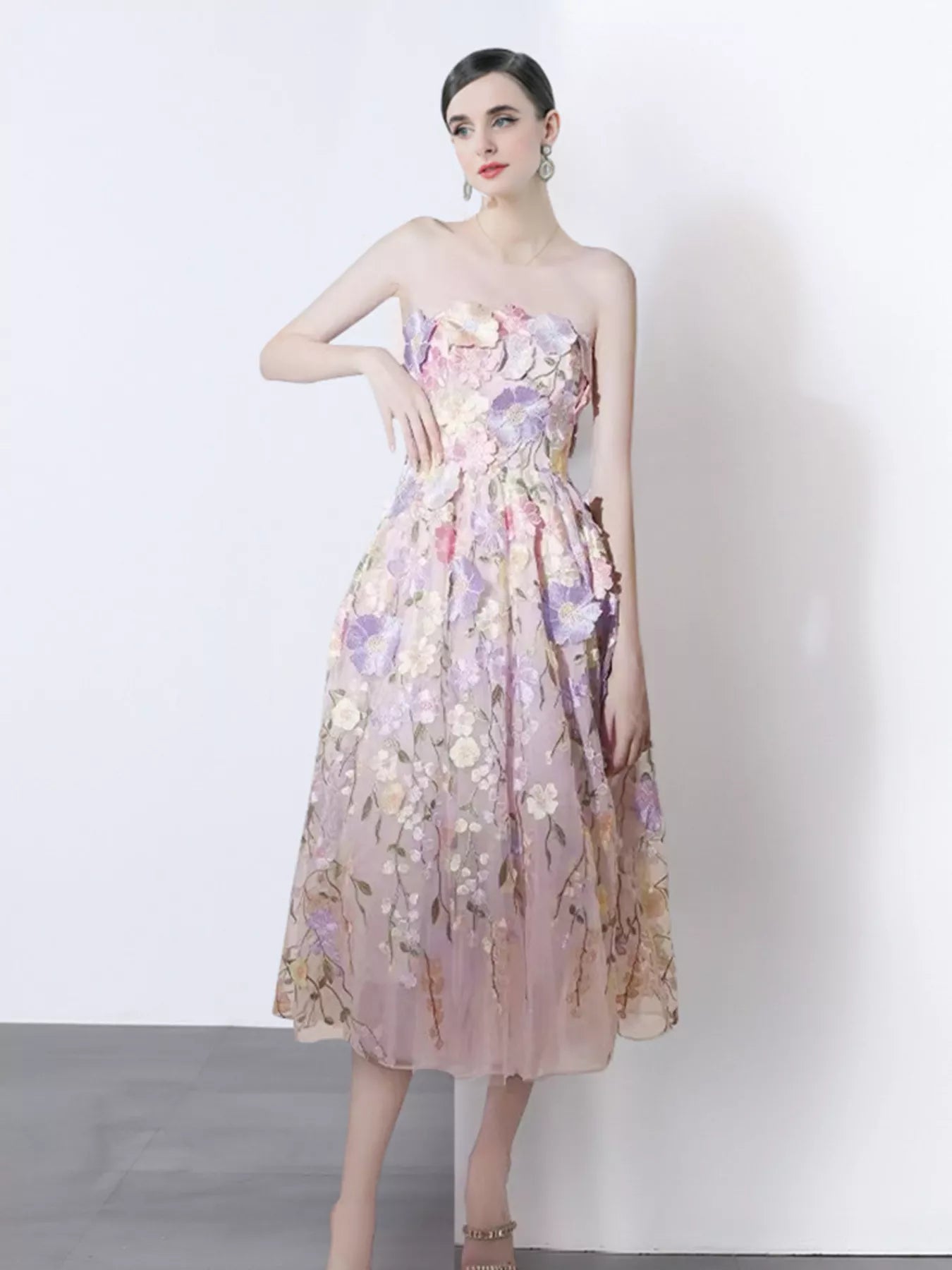 NEWYORKLISTED STYLE COLLECTION: Woman wearing a floral strapless dress against a white background