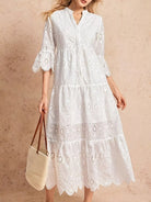 NEWYORKLISTED STYLE COLLECTION: Woman wearing a white lace dress holding a straw bag against a beige background