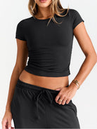 NEWYORKLISTED COMFORT COLLECTION: Person wearing a black crop top and black pants on a white background