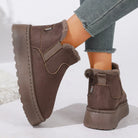 NEWYORKLISTED SHOE COLLECTION: A pair of women's brown suede-look ankle boots with plush faux-fur lining, shown on a model wearing gray frayed-hem jeans against a clean white background.