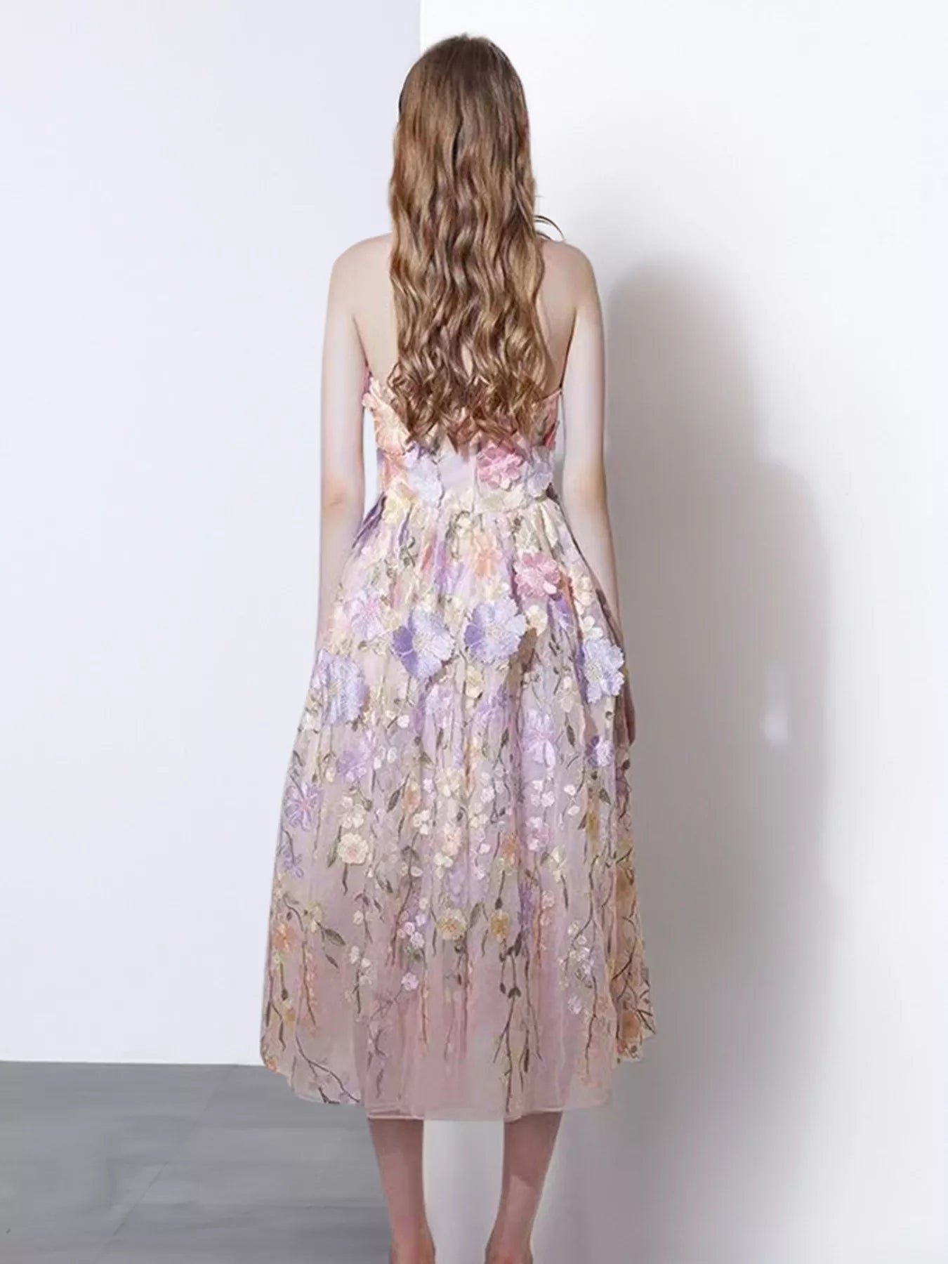 NEWYORKLISTED STYLE COLLECTION: Woman wearing a floral dress with a white background