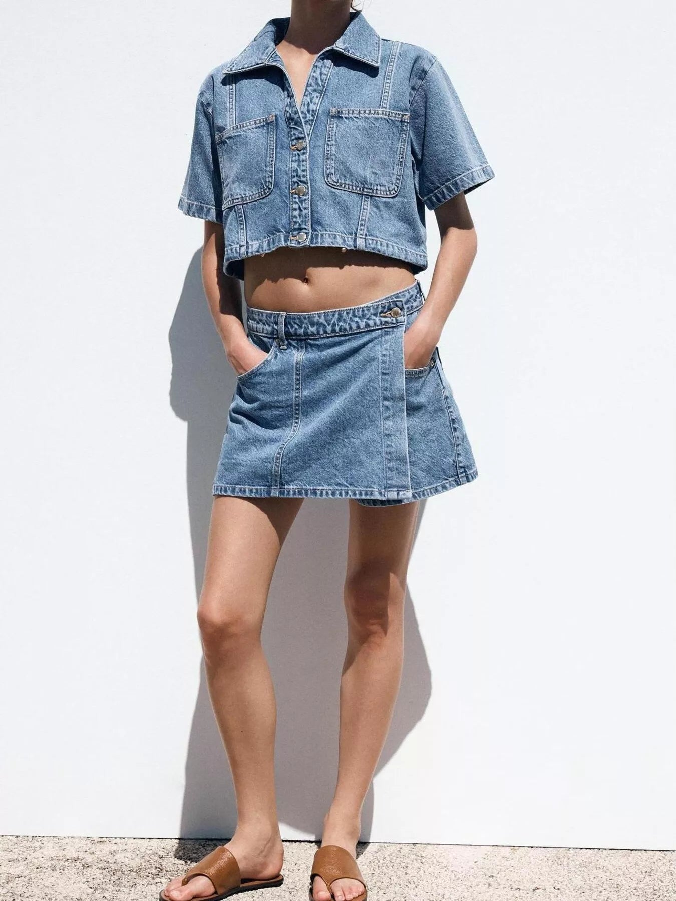 NEWYORKLISTED STYLE COLLECTION: Person wearing a denim outfit with a jacket and skirt on a white background