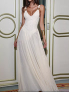 NEWYORKLISTED STYLE COLLECTION: Woman wearing a white dress with gold arm bands in an elegant interior setting.