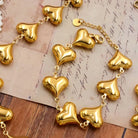 NYLD Glamour Collection by NEWYORKLISTED: Gold heart-shaped bracelet on a textured surface