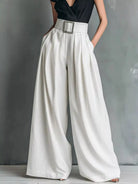 NEWYORKLISTED STYLE COLLECTION: White wide-leg pants worn with a black top on a gray background
