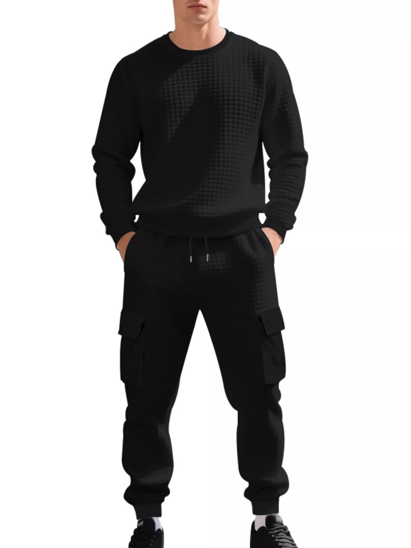 NEWYORKLISTED ATLAS MEN'S COLLECTION: A man wearing a black long-sleeve crewneck sweatshirt and matching black cargo jogger pants with a subtle geometric pattern, shown against a plain white background.