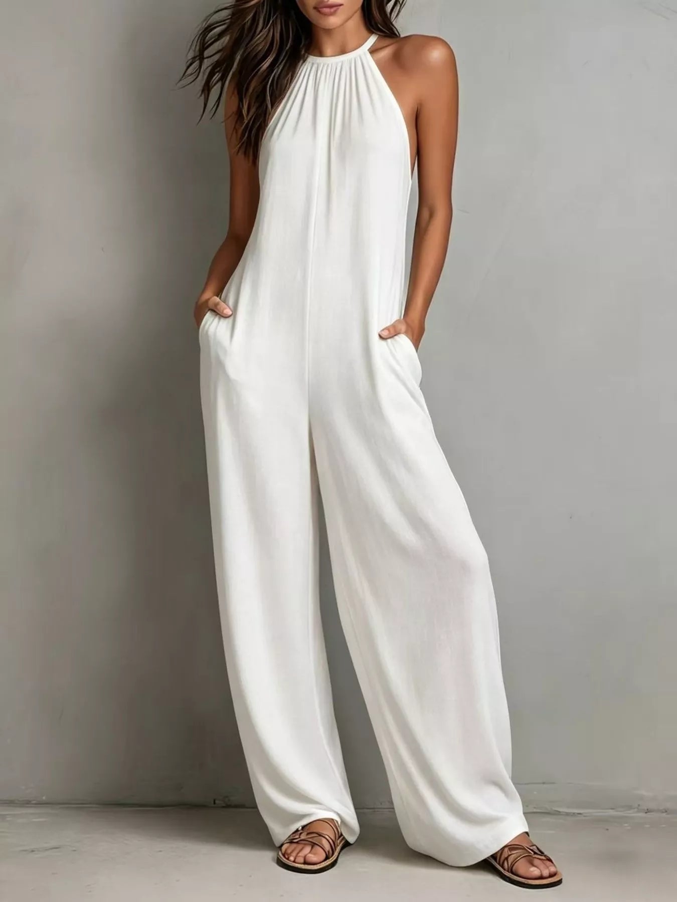 NEWYORKLISTED STYLE COLLECTION: Woman wearing a white jumpsuit against a plain background