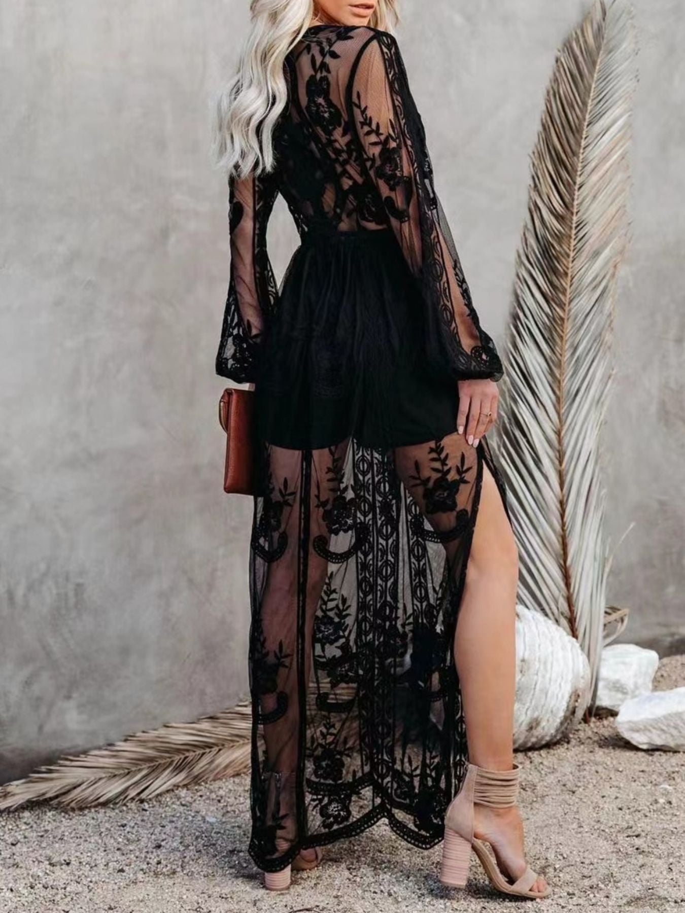 NEWYORKLISTED STYLE COLLECTION: Woman wearing a black lace dress with sheer panels against a neutral background