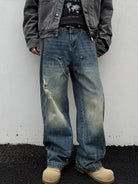 NEWYORKLISTED ATLAS MEN's COLLECTION: Person wearing distressed blue jeans and a dark jacket against a white wall.