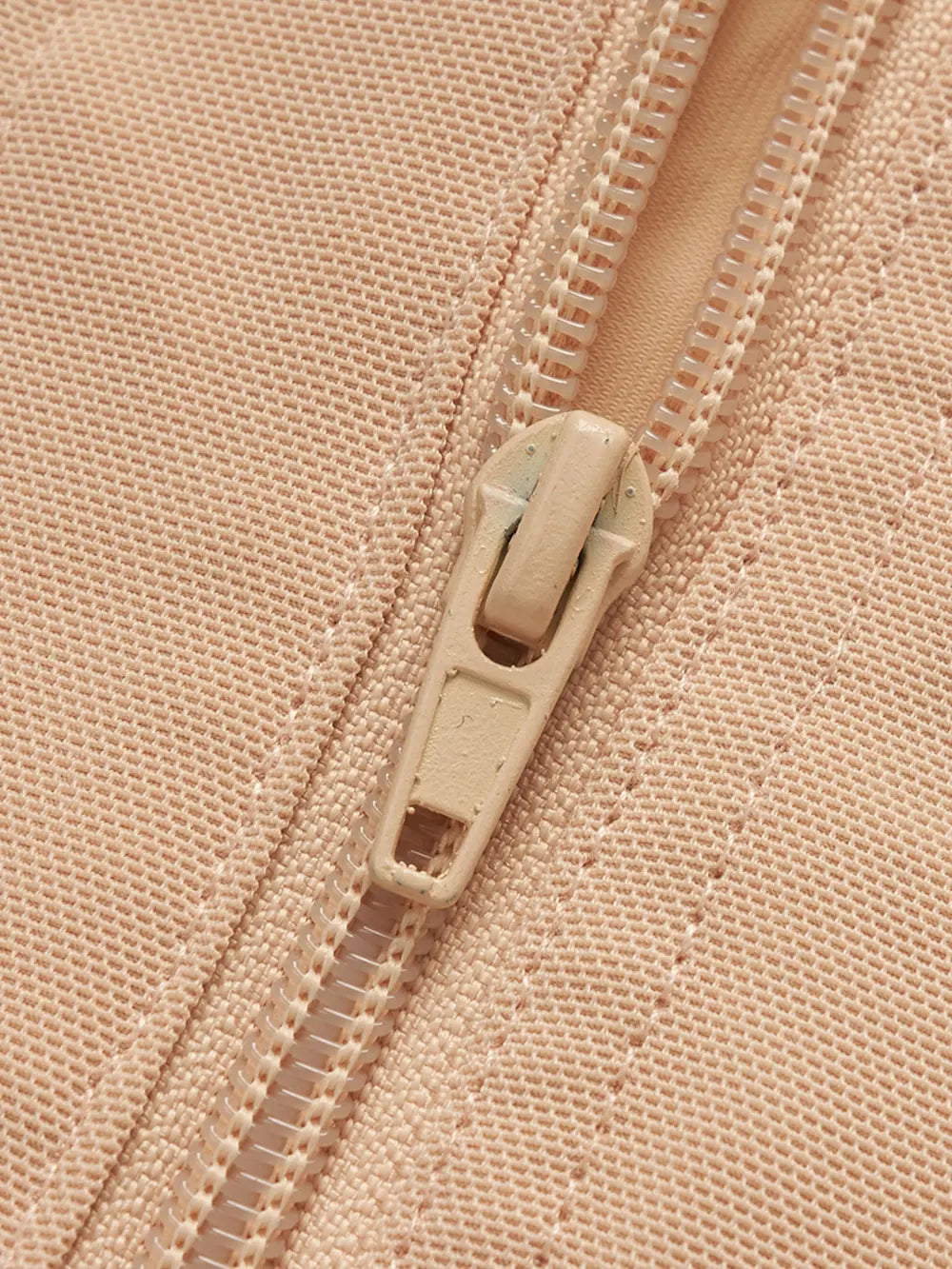NEWYORKLISTED Intimate Apparel: Close-up of a beige zipper on a matching fabric background