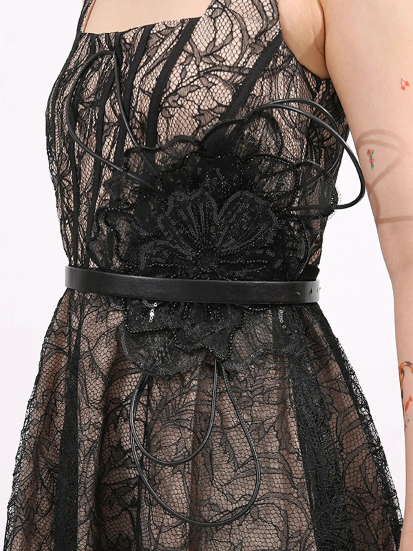 NEWYORKLISTED RUNWAY STYLE: Black lace dress with a belt on a white background