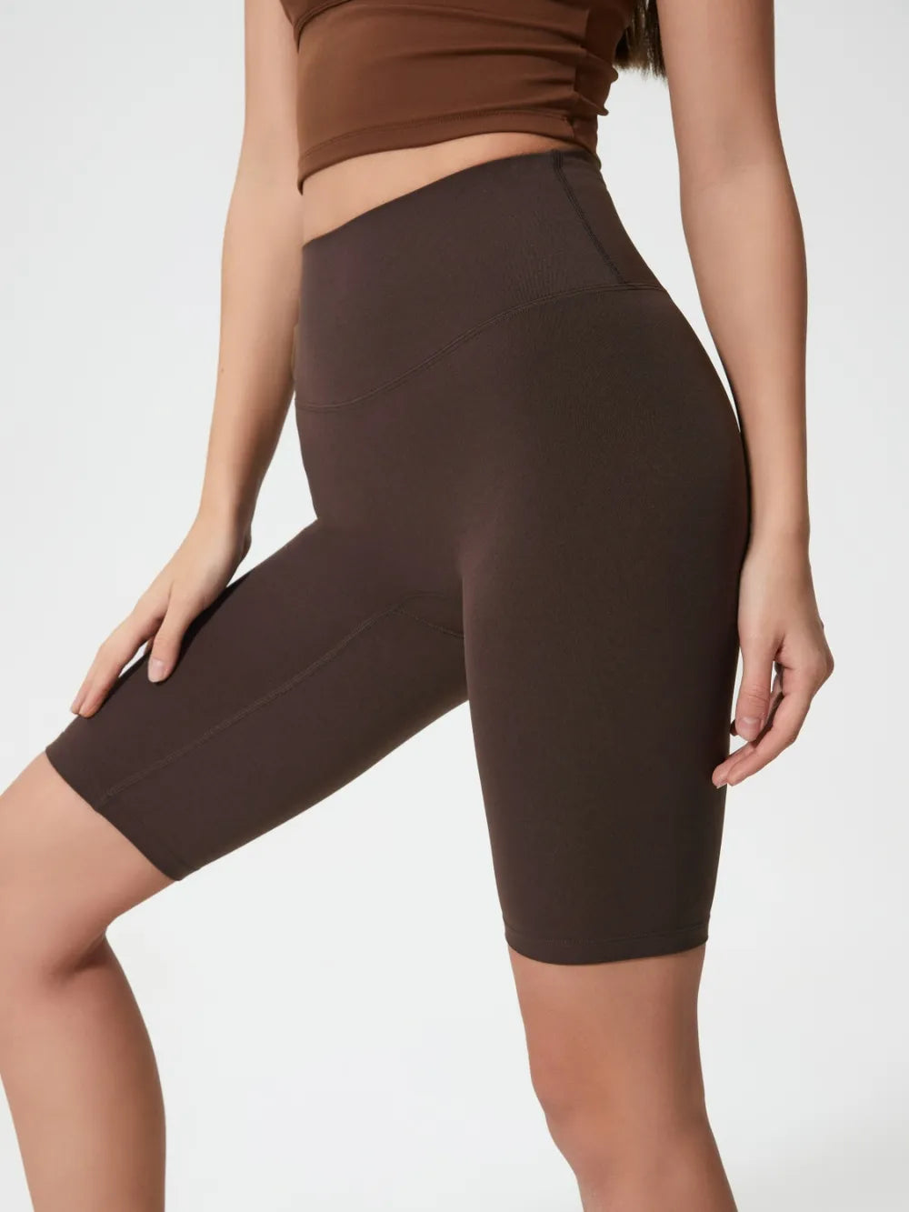 Brown athletic shorts worn by a person on a plain background