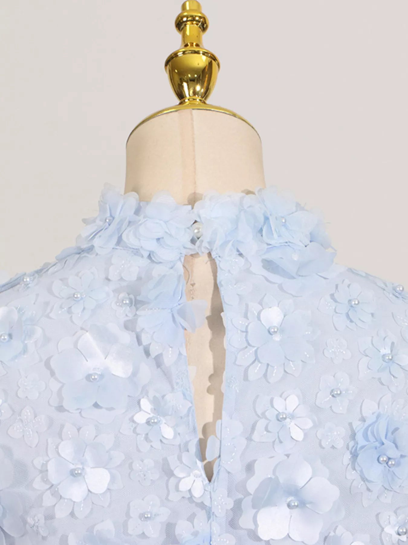 NEWYORKLISTED STYLE COLLECTION: Light blue floral dress on a mannequin with a plain background