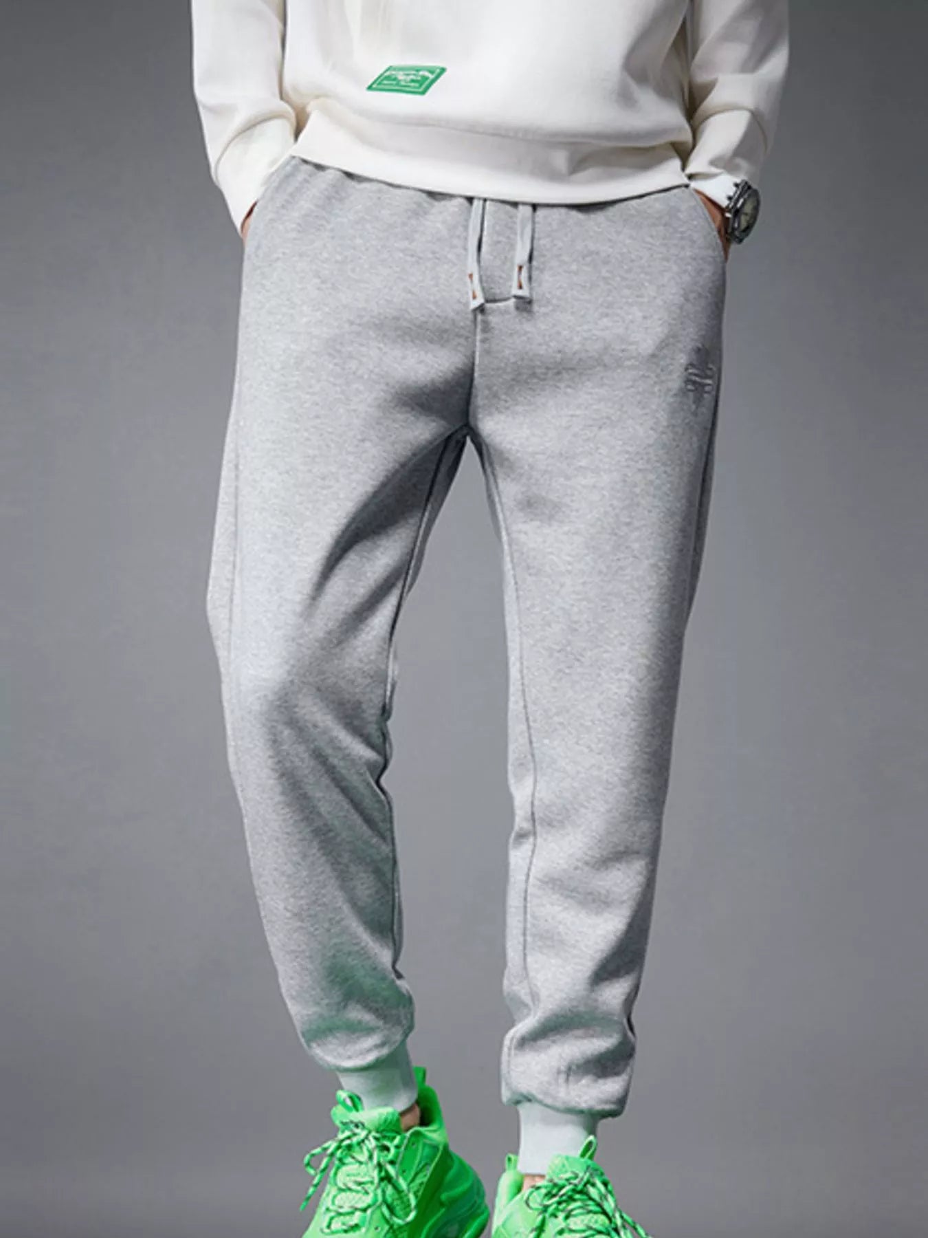 NEWYORKLISTED ATLAS MEN's COLLECTION: Person wearing gray sweatpants and green sneakers on a gray background