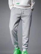 NEWYORKLISTED ATLAS MEN's COLLECTION: Person wearing gray sweatpants and green sneakers on a gray background