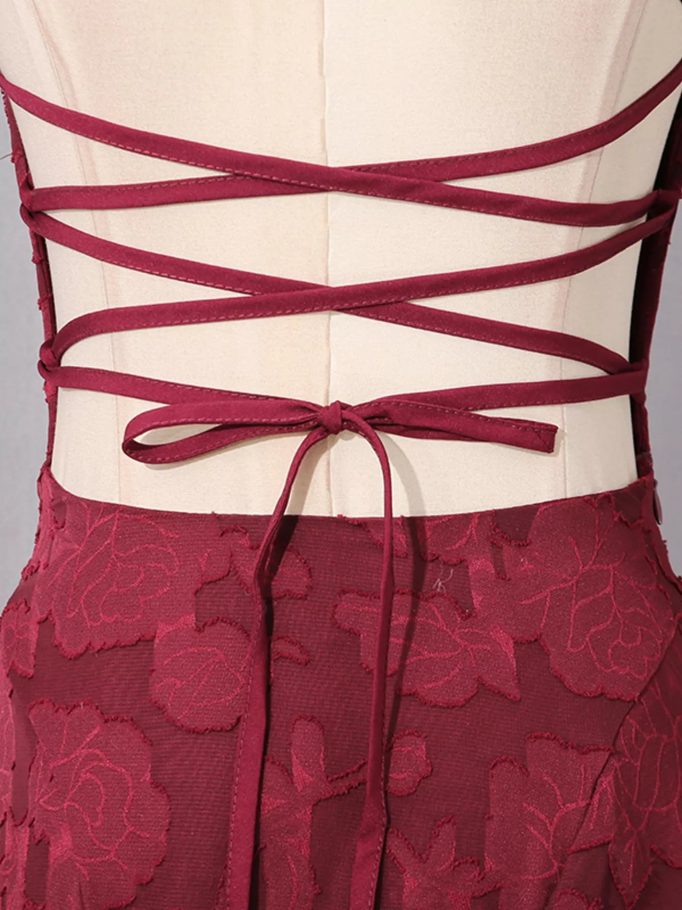 NEWYORKLISTED STYLE COLLECTION: Red lace dress with intricate back design on a mannequin against a gray background