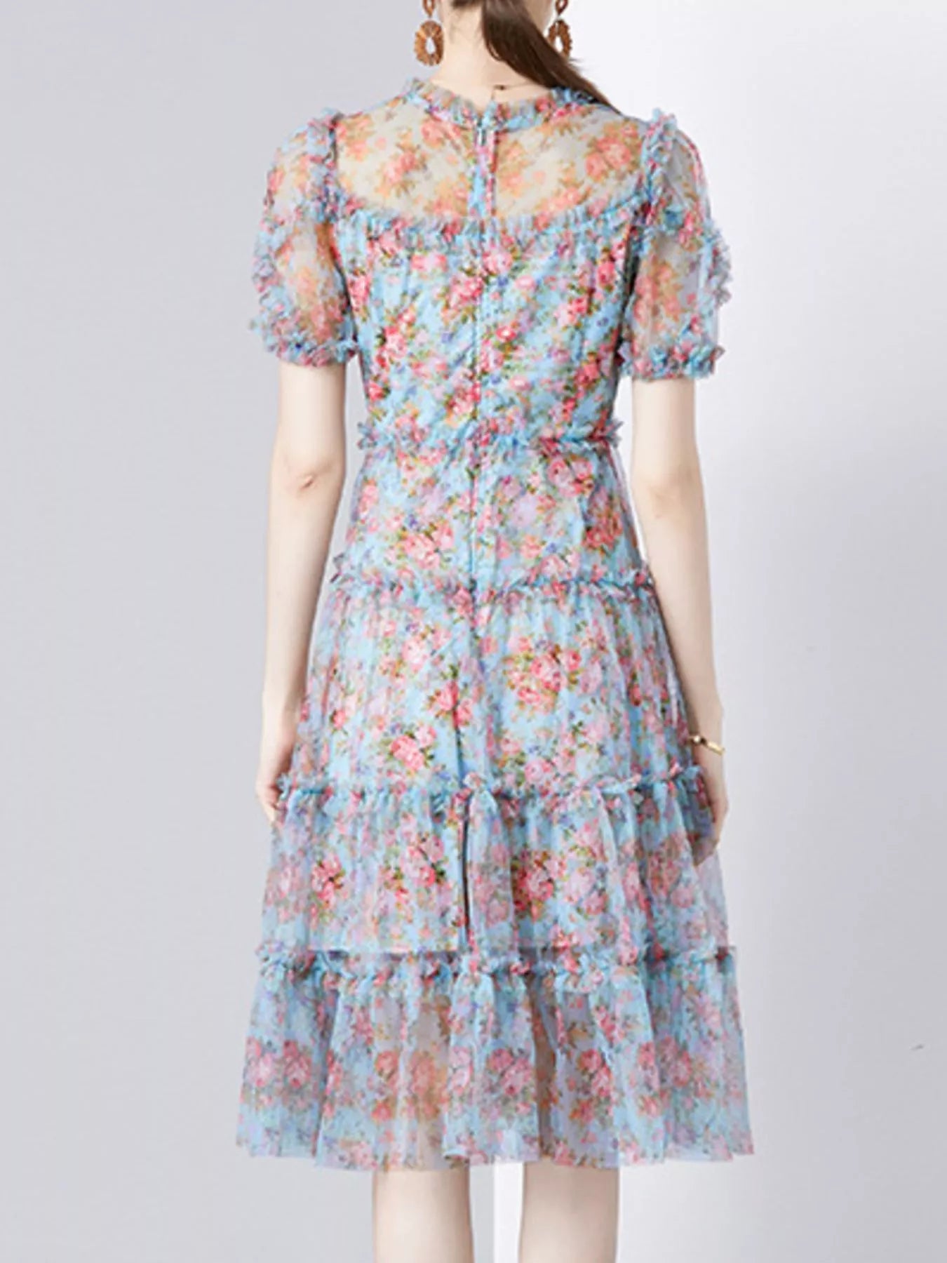 NEWYORKLISTED STYLE COLLECTION: Woman wearing a floral dress on a plain background
