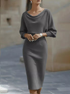 NEWYORKLISTED STYLE COLLECTION: Woman wearing a gray dress standing against a neutral background