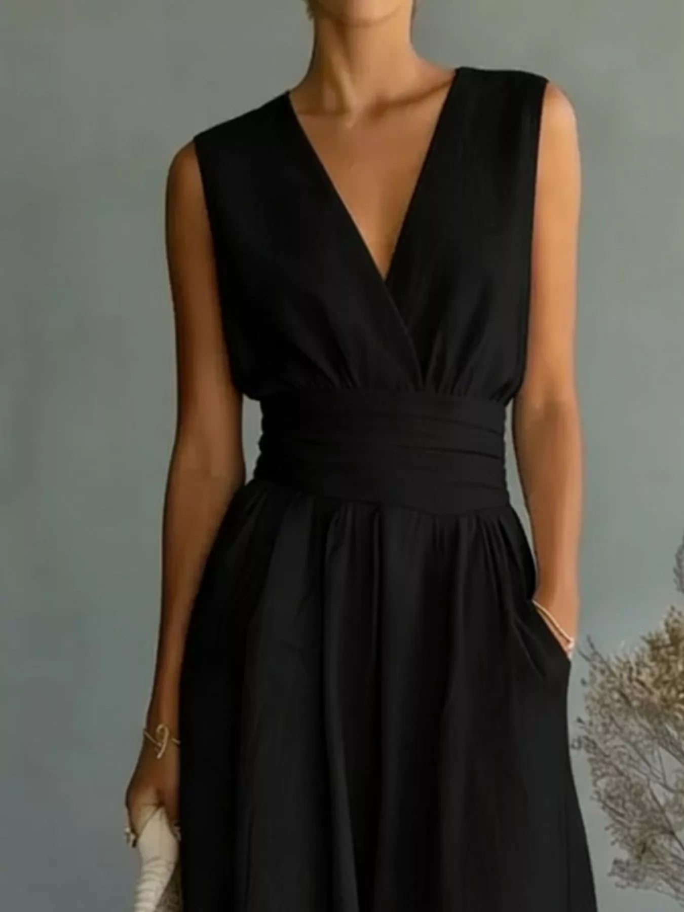 NEWYORKLISTED STYLE COLLECTION: Black sleeveless dress worn by a person against a neutral background