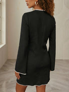 NEWYORKLISTED STYLE COLLECTION: Person wearing a black dress with white trim in a neutral setting