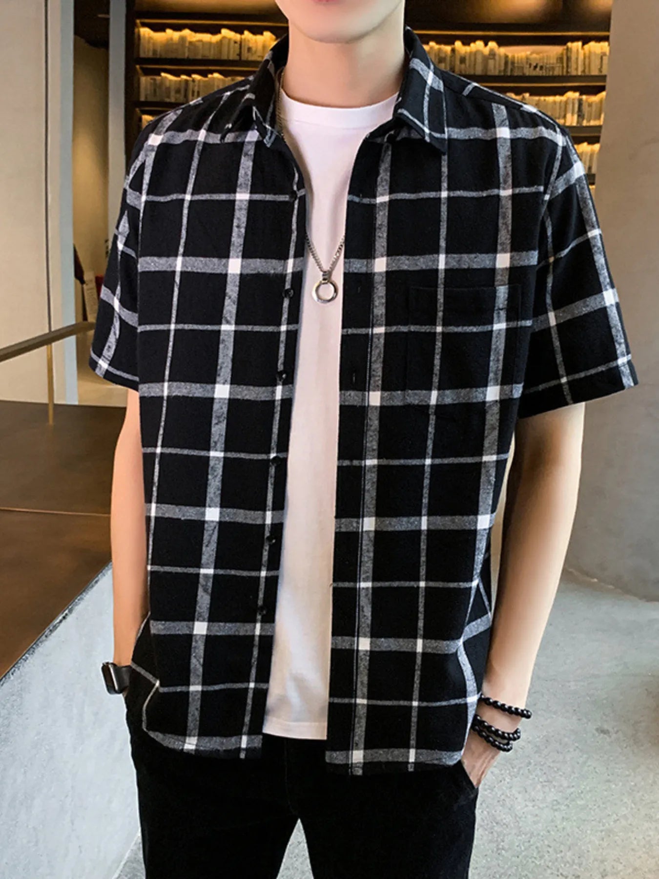 NEWYORKLISTED ATLAS MEN'S COLLECTION: Person wearing a black and white checkered shirt with a plain background