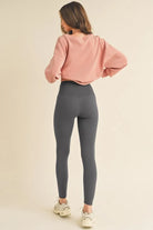 NEWYORKLISTED ACTIVEWEAR Person wearing a pink sweatshirt and gray leggings on a beige background