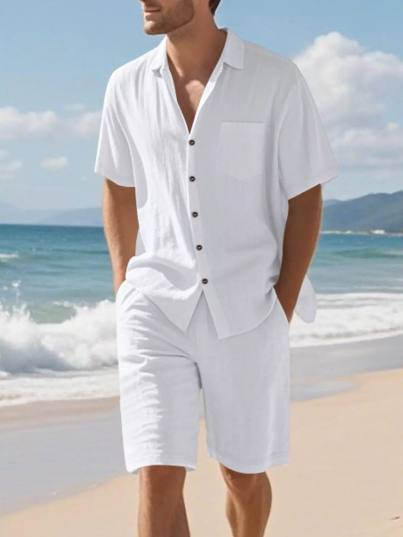NEWYORKLISTED ATLAS MEN'S COLLECTION: Man wearing a white outfit with a button-up shirt and shorts on a beach.